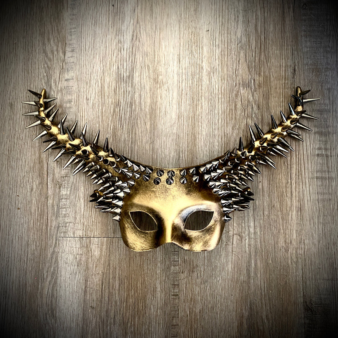 A metallic gold spike goat horn masquerade mask for women
